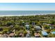 Aerial view of the neighborhood, showcasing a home nestled among lush trees with a beautiful ocean view at 409 W Indian Ave, Folly Beach, SC 29439