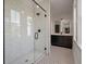Bathroom featuring a glass shower enclosure, white tile, and dark vanity with sink at 409 W Indian Ave, Folly Beach, SC 29439