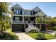 Attractive two-story coastal home with a manicured lawn and inviting entrance at 409 W Indian Ave, Folly Beach, SC 29439
