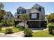Charming two-story home with a well-manicured lawn, landscaped yard and inviting staircase at 409 W Indian Ave, Folly Beach, SC 29439