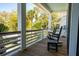 Relax on this covered front porch with rocking chairs and enjoy a tranquil, tree-lined view at 409 W Indian Ave, Folly Beach, SC 29439