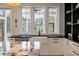 Bright kitchen with a farmhouse sink, granite countertops, white cabinetry, and a view of the landscaped yard at 409 W Indian Ave, Folly Beach, SC 29439