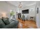Bright living room featuring hardwood floors, shiplap accent wall, and a dining area at 409 W Indian Ave, Folly Beach, SC 29439