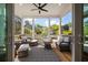 Inviting screened porch with comfortable wicker furniture, patterned rug, and views of the landscaped yard at 409 W Indian Ave, Folly Beach, SC 29439