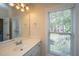 Bathroom with white vanity, large mirror, and window with exterior view at 4407 Wild Thicket Ln, North Charleston, SC 29420