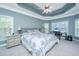 Calming bedroom with tray ceilings, two windows, and an adjacent desk space for functionality at 4407 Wild Thicket Ln, North Charleston, SC 29420