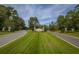 Community entrance featuring a sign, landscaping, and a well-maintained road at 4407 Wild Thicket Ln, North Charleston, SC 29420