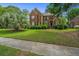 Traditional brick two-story home with a landscaped front yard and mature trees, sidewalk at 4407 Wild Thicket Ln, North Charleston, SC 29420