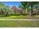 Beautiful two-story brick home featuring a well-manicured lawn and mature landscaping at 4407 Wild Thicket Ln, North Charleston, SC 29420