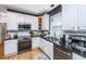 Bright kitchen featuring black countertops, white cabinets, stainless appliances, and hardwood flooring at 4407 Wild Thicket Ln, North Charleston, SC 29420