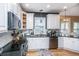 Updated kitchen featuring black countertops, white cabinets, stainless appliances, and hardwood flooring at 4407 Wild Thicket Ln, North Charleston, SC 29420