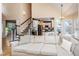 Bright living room featuring neutral walls, staircase, and an open view of a modern kitchen with white cabinetry at 4407 Wild Thicket Ln, North Charleston, SC 29420
