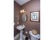 Stylish powder room featuring a pedestal sink, round mirror, and elegant wall art at 4407 Wild Thicket Ln, North Charleston, SC 29420