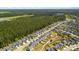 Aerial view of a well-planned suburban community bordered by dense woods, showcasing rows of single-Gathering homes at 476 Foxbank Plantation Blvd, Moncks Corner, SC 29461
