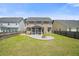 The backyard offers green lawn, privacy fencing, a patio area with a fire pit, and the home's screened in porch at 476 Foxbank Plantation Blvd, Moncks Corner, SC 29461