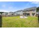 The expansive backyard boasts a green lawn, fire pit, and a view of the home with its screened-in porch at 476 Foxbank Plantation Blvd, Moncks Corner, SC 29461