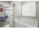 Bright bathroom featuring a soaking tub, window with blinds, and a door that opens to the main bedroom at 476 Foxbank Plantation Blvd, Moncks Corner, SC 29461