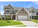 Attractive two-story home with an attached garage, inviting front porch, and manicured lawn at 476 Foxbank Plantation Blvd, Moncks Corner, SC 29461