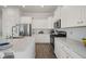 Bright kitchen with white cabinets, stainless steel appliances, and a large island with quartz countertops at 500 W Respite Ln, Summerville, SC 29483
