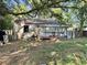 Exterior view of a backyard with overgrown grass, fallen leaves, and a weathered structure at 5901 Sedgefield Dr, Hanahan, SC 29410