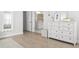 Bright, airy bedroom with light wood floors, white dresser, and a doorway leading to the bathroom at 606 Dunswell Dr, Summerville, SC 29486