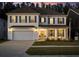 Charming two-story home with a two-car garage, well-manicured lawn, and inviting front porch at dusk at 606 Dunswell Dr, Summerville, SC 29486