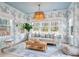 Bright living room featuring heron wallpaper, natural light, modern sofa, and a unique rattan chandelier at 606 Dunswell Dr, Summerville, SC 29486