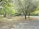 Picnic table, outdoor structure, and several trees and foliage in an open backyard with a light colored dirt ground at 620 Coral Acres Dr, Moncks Corner, SC 29461
