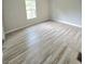Bright bedroom with light-toned walls, light wood-look vinyl flooring, and a window offering natural light at 620 Coral Acres Dr, Moncks Corner, SC 29461