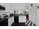 Well-maintained kitchen with black and white tile flooring, black appliances, and adjacent living spaces at 739 Stiles Dr, Charleston, SC 29412