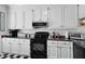 A bright kitchen features white cabinets and black appliances at 739 Stiles Dr, Charleston, SC 29412