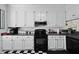 Charming kitchen with white cabinets, red hardware, modern appliances, and decorative backsplash at 739 Stiles Dr, Charleston, SC 29412