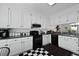 Classic white kitchen featuring contrasting black appliances, granite counters, and black and white checkered flooring at 739 Stiles Dr, Charleston, SC 29412