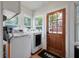 Bright laundry room features modern washer, dryer, wood door, and natural light from multiple windows at 798 Rutledge Ave, Charleston, SC 29403