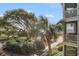Scenic view of a sandy beach with lush greenery, palm trees and a charming balcony with outdoor seating at 9000 Palmetto Dr # 202-C, Isle of Palms, SC 29451