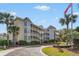 Low country condominium building, palm trees, and the American flag on a sunny day at 9000 Palmetto Dr # 202-C, Isle of Palms, SC 29451