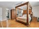 Elegant bedroom with a wood four-poster bed, ample closet space and light filled wood floors at 939 Mikell Dr, Charleston, SC 29412