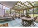 Inviting sunroom featuring a swinging daybed, natural light and outdoor views, and a wooden dining set at 939 Mikell Dr, Charleston, SC 29412