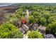 Aerial view of yellow home in neighborhood with proximity to marsh and waterway at 1002 Blockade Runner Ct, Charleston, SC 29414