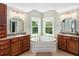 Bright bathroom with dual vanities, a corner tub, and natural light at 1002 Blockade Runner Ct, Charleston, SC 29414