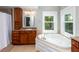 Bright bathroom featuring a large soaking tub, natural light, and wood cabinets at 1002 Blockade Runner Ct, Charleston, SC 29414
