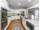 A well-lit kitchen featuring white cabinetry, stainless steel appliances, and granite countertops with wood flooring at 1002 Blockade Runner Ct, Charleston, SC 29414