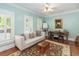 Cozy living area with a plush sofa, a vintage trunk, and a painting near the shutters, enhancing its inviting charm at 1002 Blockade Runner Ct, Charleston, SC 29414