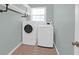 Functional laundry room with modern white washer and dryer units and overhead shelving at 1006 Wayfarer Ln, Charleston, SC 29412