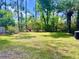 Expansive backyard with lush green grass and mature trees, perfect for outdoor activities at 1009 Highland Pines Rd, Ladson, SC 29456
