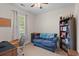 Inviting bedroom featuring cozy blue sofa, bookshelf filled with books, and window with natural light at 102 Vango Dr, Goose Creek, SC 29445