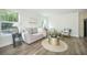 Bright and airy living room with light colored walls, hardwood floors, and comfortable furnishings at 103 Bush Dr, Bonneau, SC 29431