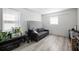 Bright bedroom with a modern gray couch and window providing natural light, showcasing a cozy interior at 1104 Margaret Dr, Ladson, SC 29456