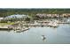 Aerial view of a marina with yachts and other vessels docked near waterfront townhomes and a blue roofed building at 113 High Hammock Villas, Seabrook Island, SC 29455