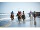 Wonderful view of horses and their riders walking along a beach with clear water at 113 High Hammock Villas, Seabrook Island, SC 29455